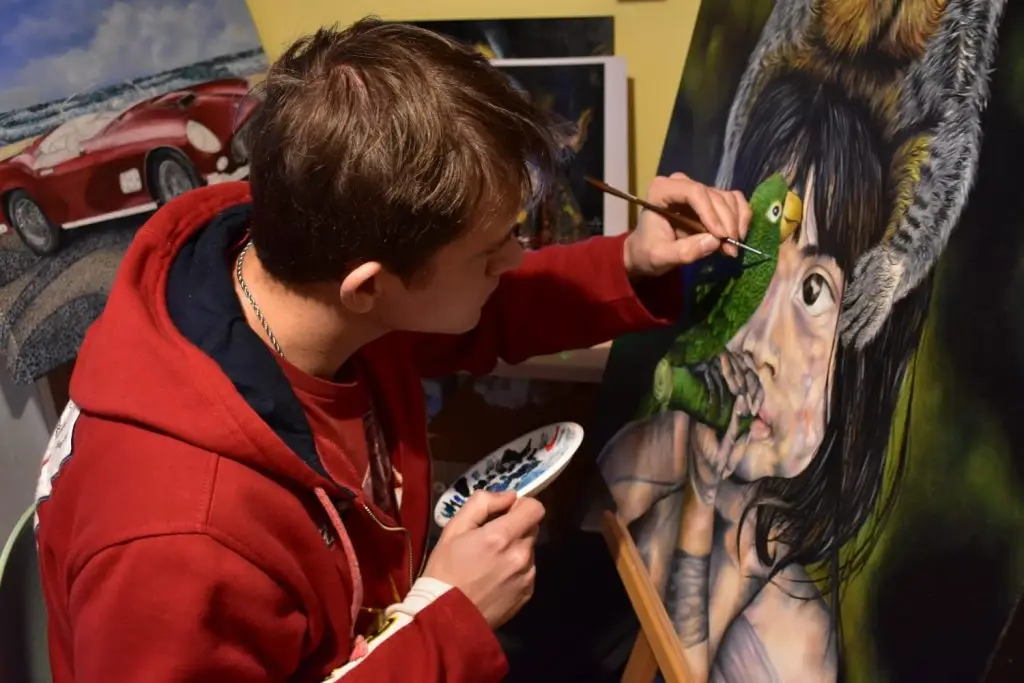 Willian dipingendo un quadro ad olio dove ritratta la cultura Amazzonica